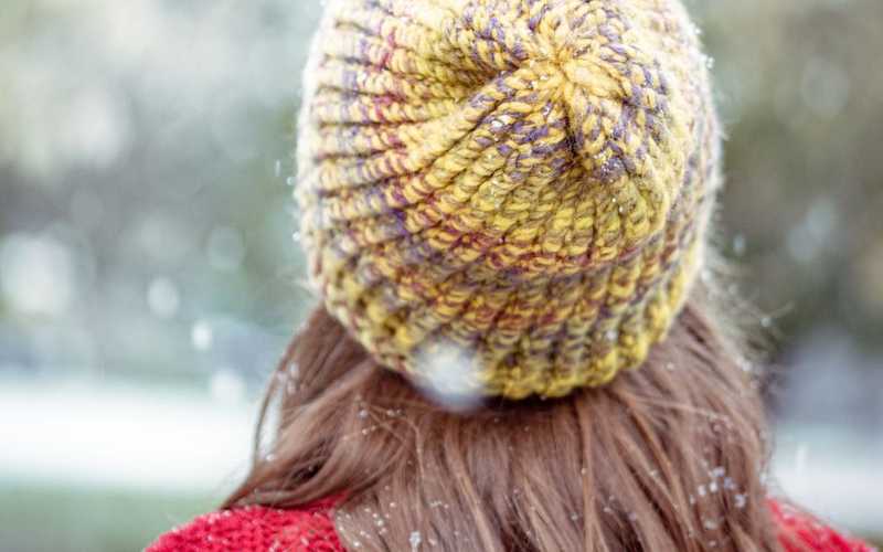 woman in red shirt wearing yellow knit cap